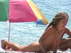 Slim dreadlocked hottie plays on a hot nude beach